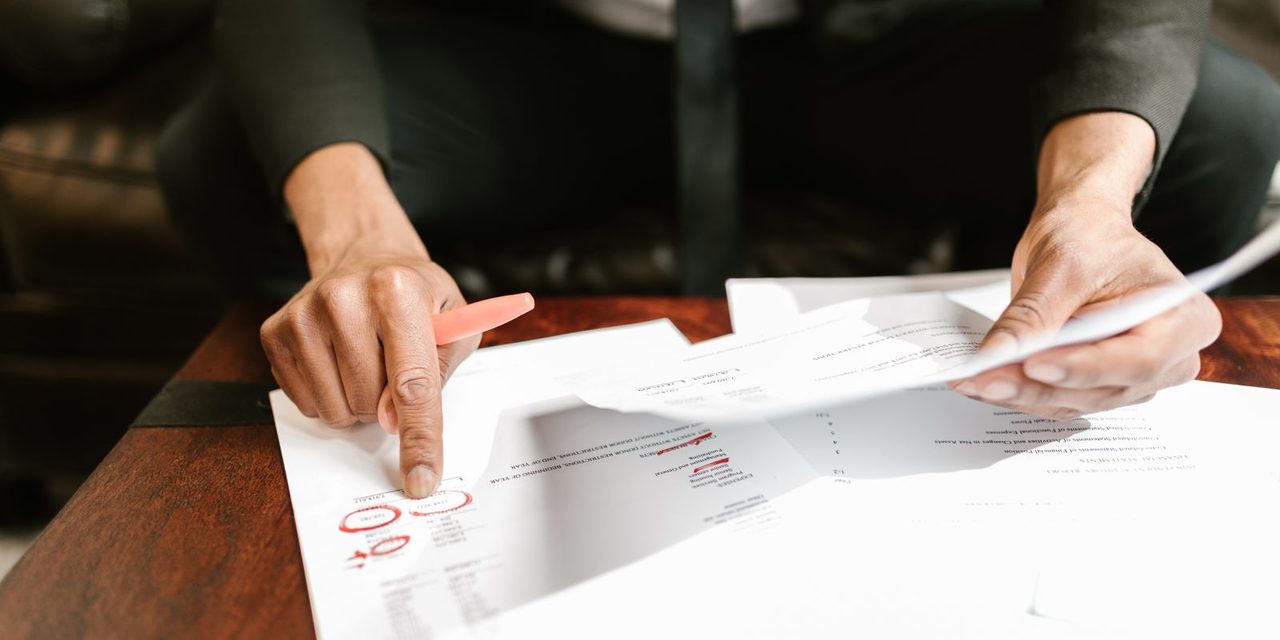 Gestionnaire de paie calédonien vérifiant un bulletin de salaire et le calcul de la CCS dans un bureau à Nouméa