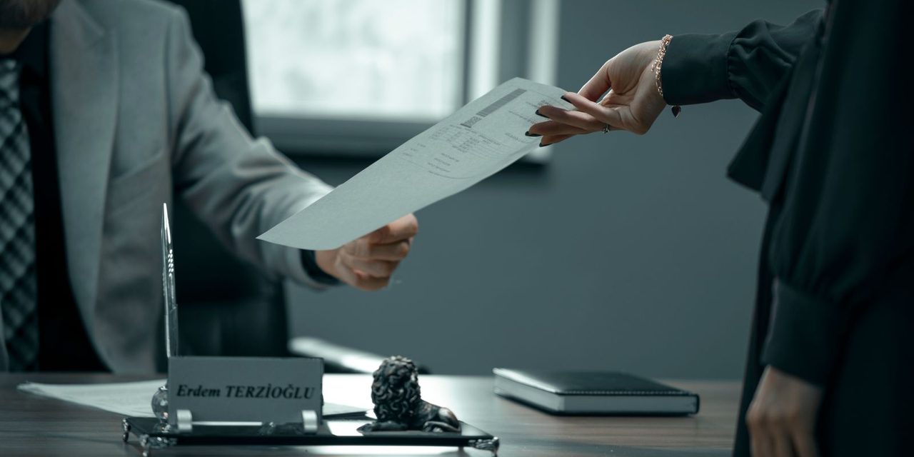 Un dirigeant calédonien remet un certificat de travail à un salarié dans un bureau à Nouméa