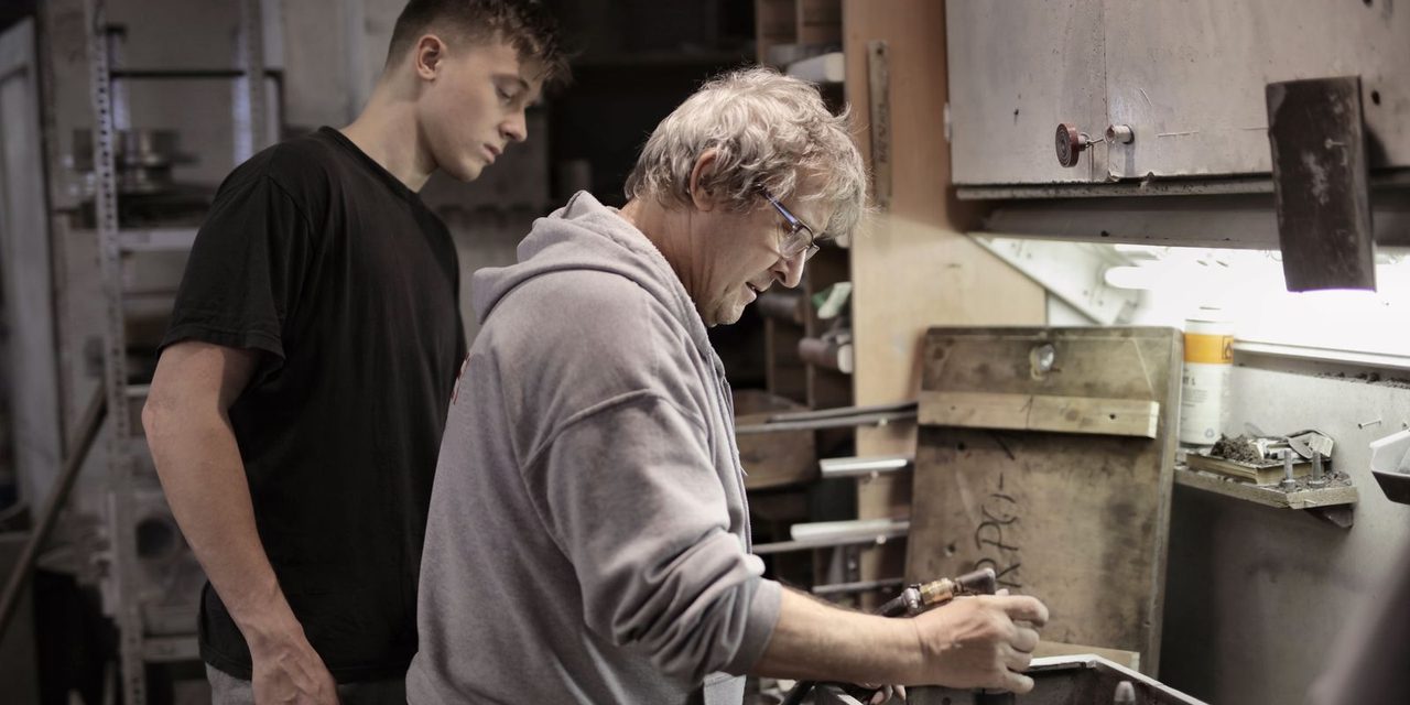 Un jeune apprenti en formation aux côtés de son maître d'apprentissage dans un atelier en Nouvelle-Calédonie