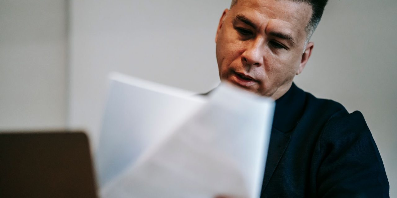 Dirigeant d'entreprise calédonien préparant sa déclaration CAFAT trimestrielle sur ordinateur portable dans son bureau à Nouméa