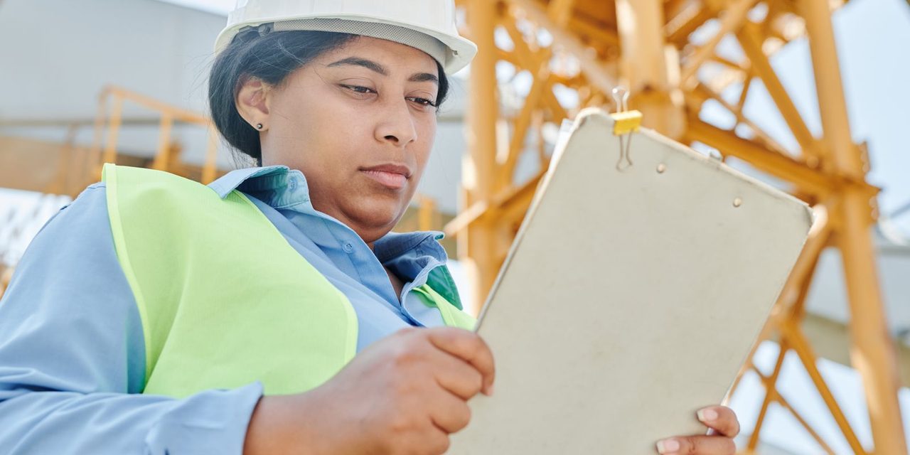 Un responsable en gilet de sécurité évalue les risques sur un site de travail en Nouvelle-Calédonie, document à la main