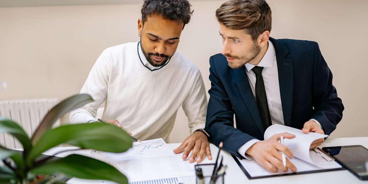 Un dirigeant et une salariée échangent autour d'un bureau lors d'un entretien individuel dans une entreprise calédonienne