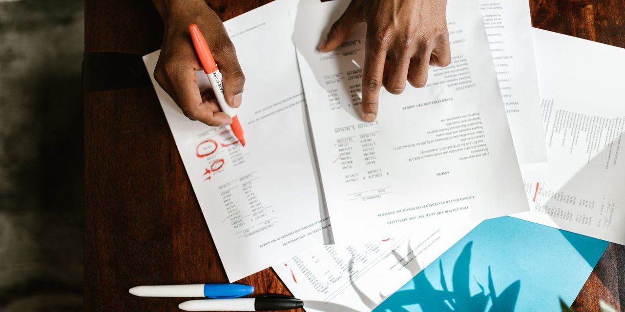 Gestionnaire de paie examinant des bulletins de salaire et des déclarations sociales dans un bureau à Nouméa