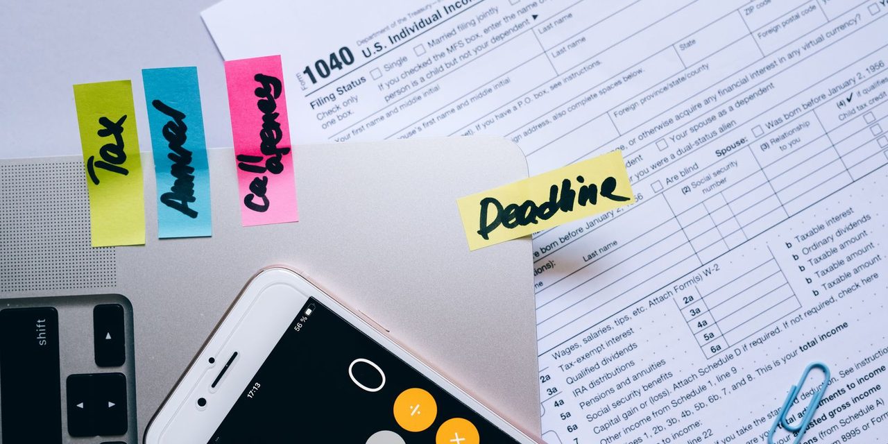 Bureau d'un gestionnaire de paie calédonien avec bulletins de salaire, calculatrice et grille de classification