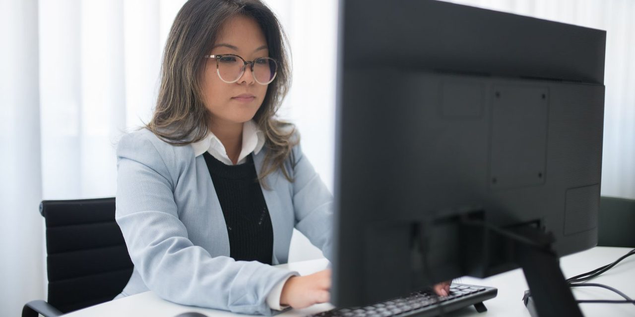 Gestionnaire RH calédonienne travaillant sur un logiciel de paie dans un bureau à Nouméa