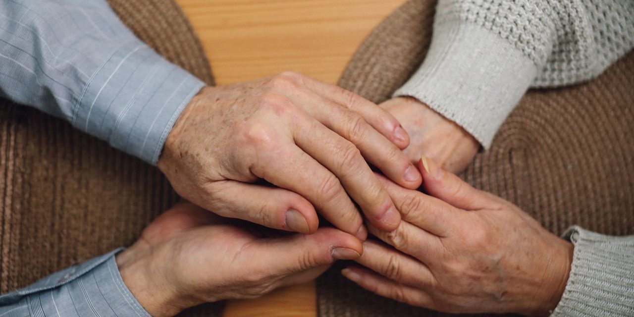 Mains d'un couple de personnes âgées posées l'une sur l'autre, symbole du soutien après le décès d'un conjoint en Nouvelle-Calédonie