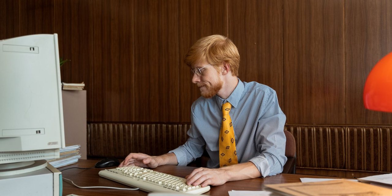 Bureau d'un employeur calédonien avec un bulletin de paie, une calculatrice et des pièces de francs Pacifique illustrant le calcul du salaire minimum garanti