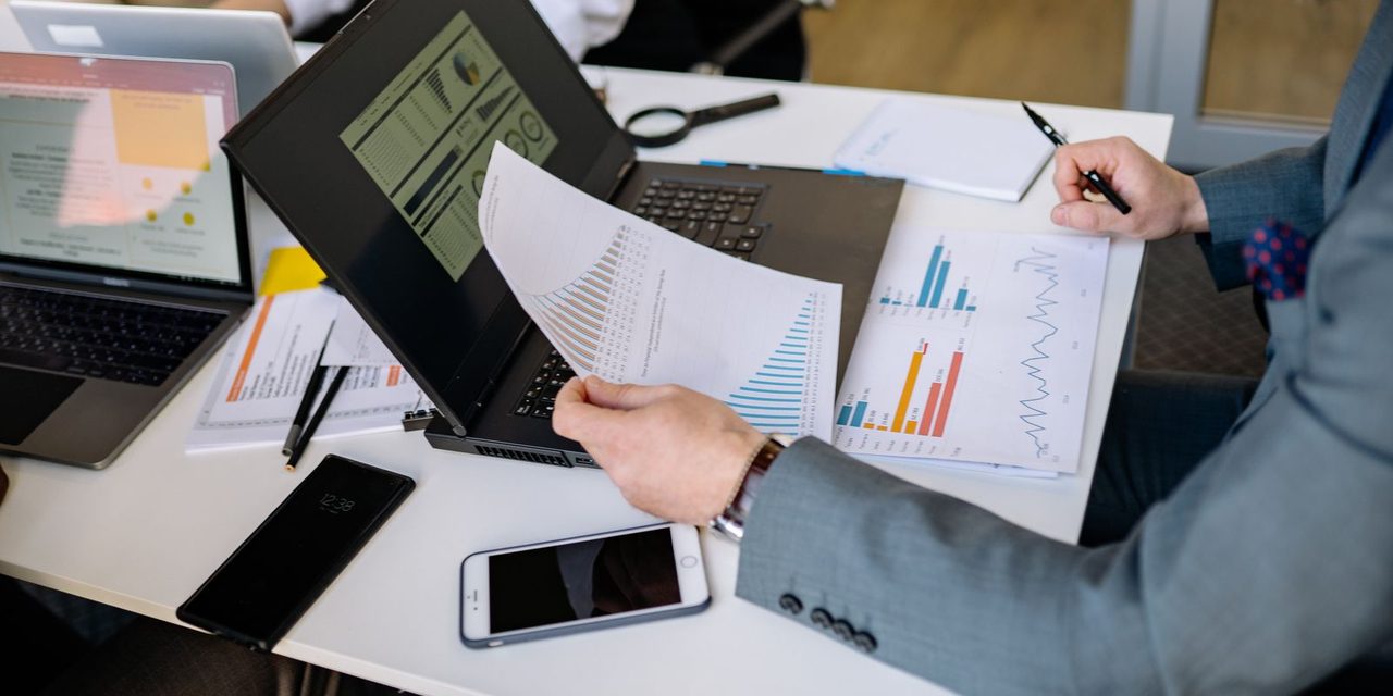 Dirigeant calédonien analysant un tableau de bord RH avec indicateurs et graphiques sur un écran d'ordinateur dans un bureau à Nouméa