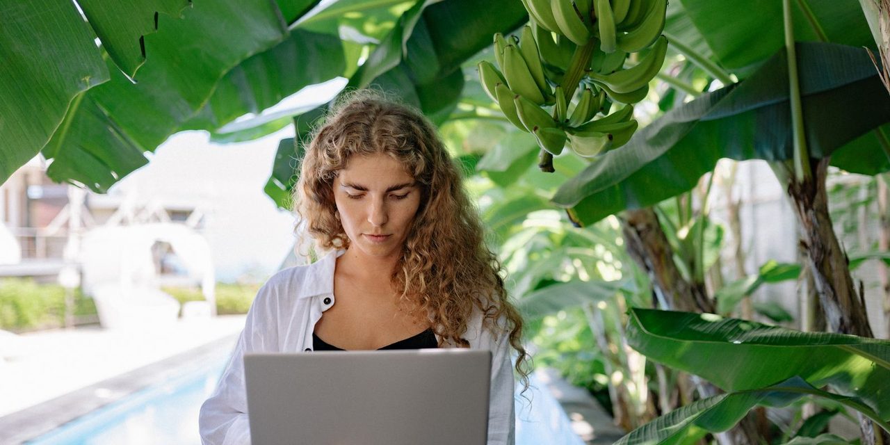 Salariée calédonienne en télétravail à domicile devant son ordinateur portable, lumière naturelle